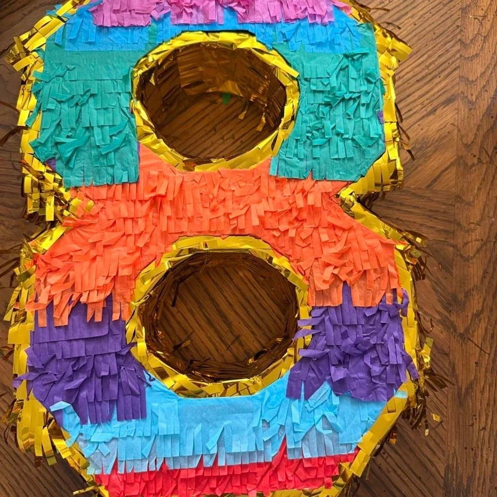 Number 8 pinata with gold trim and colorful fringed sections in various colors